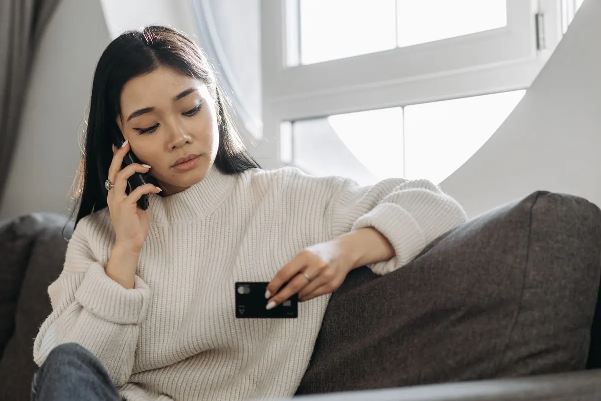 Persona revisando con gesto de preocupación los movimientos de su tarjeta en la app del celular