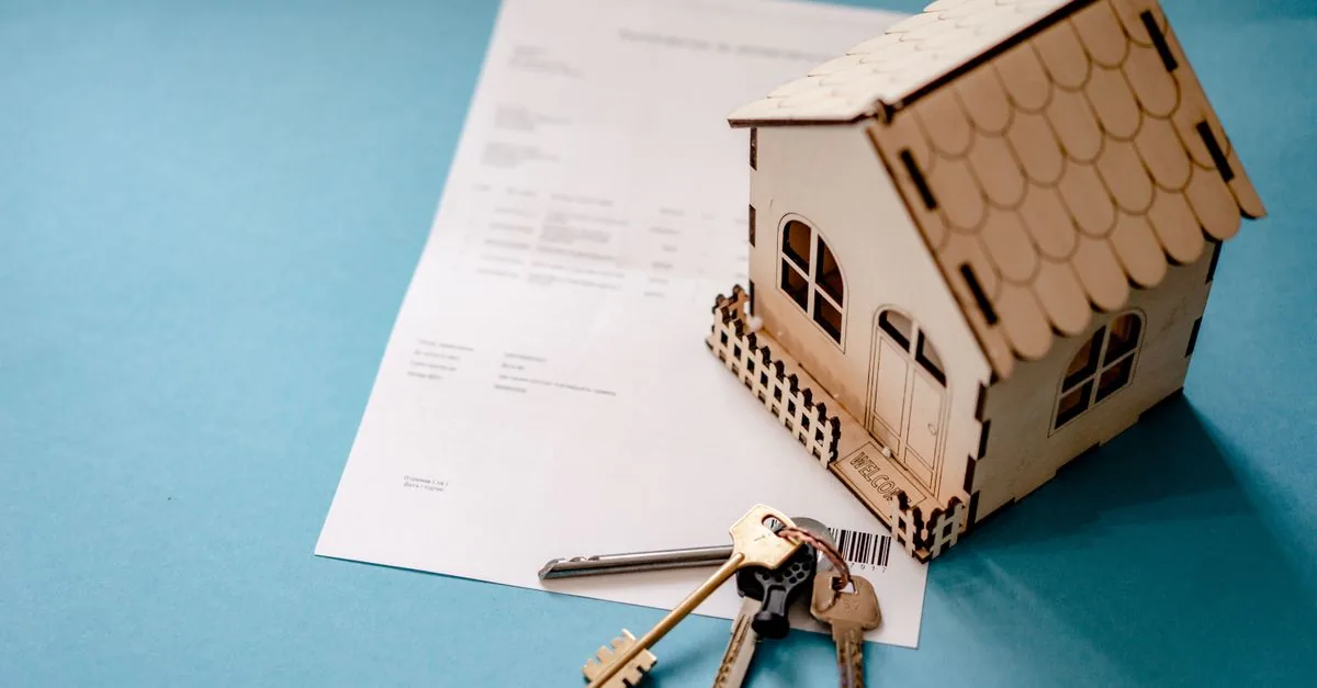 Llaves de una casa sobre una mesa junto a documentos