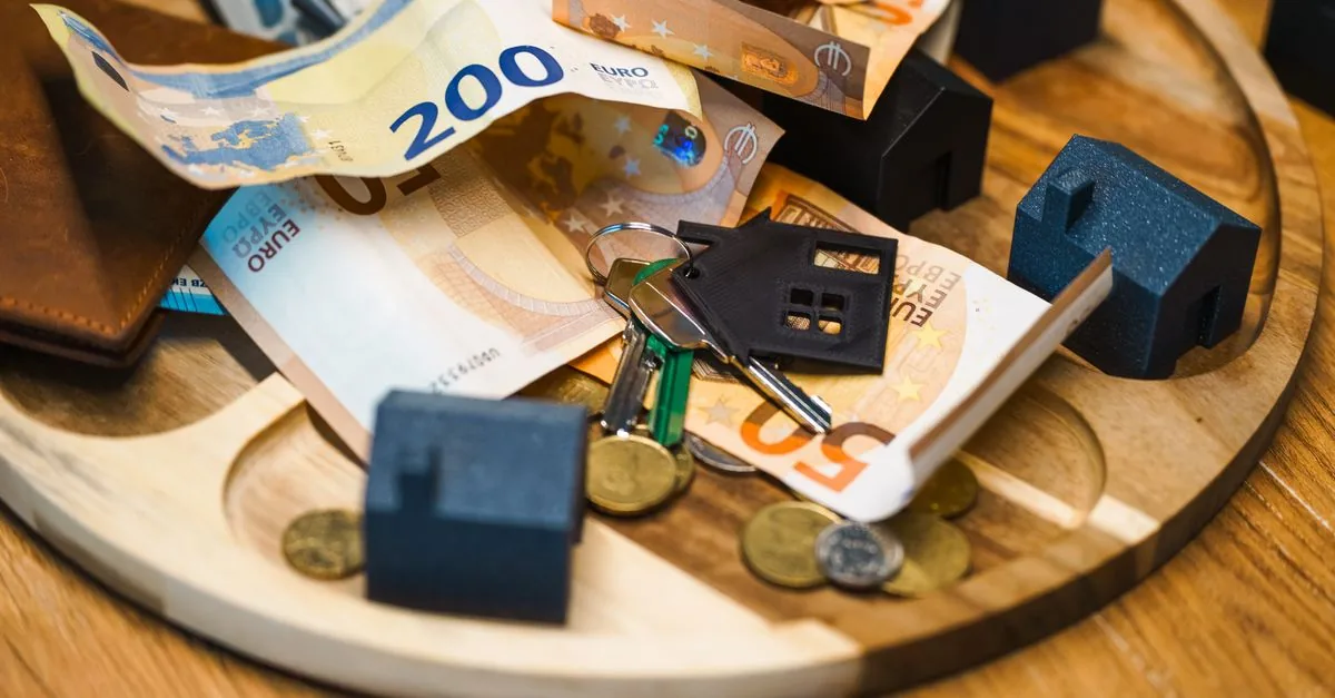 Llaves de una casa sobre monedas, ahorrar para el enganche