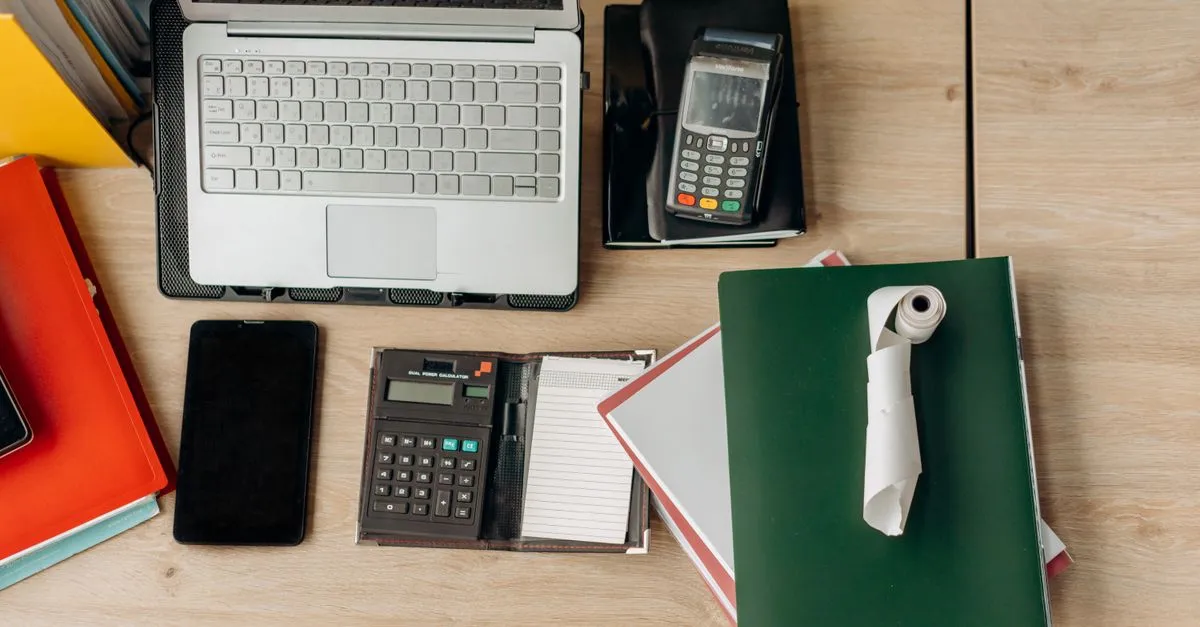 Escritorio con calculadora, recibos y libretas para ordenar los gastos