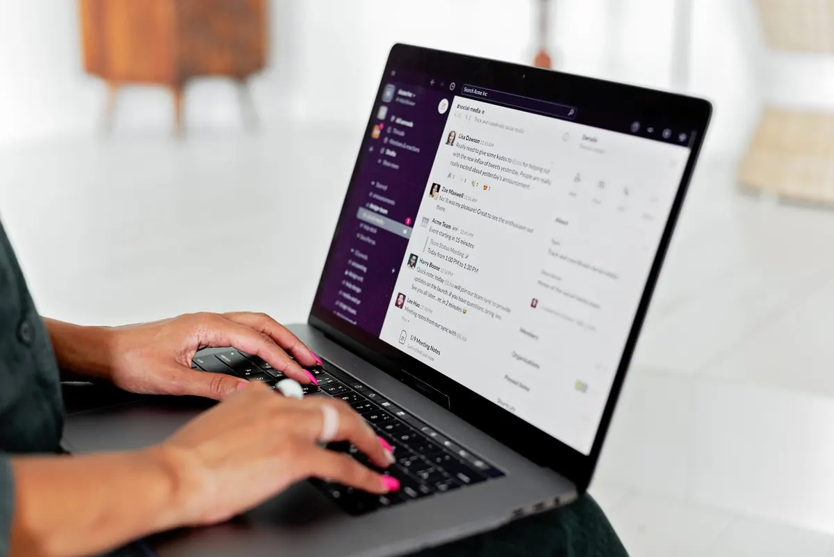 Persona revisando su bandeja de correo en una laptop sobre una mesa de madera