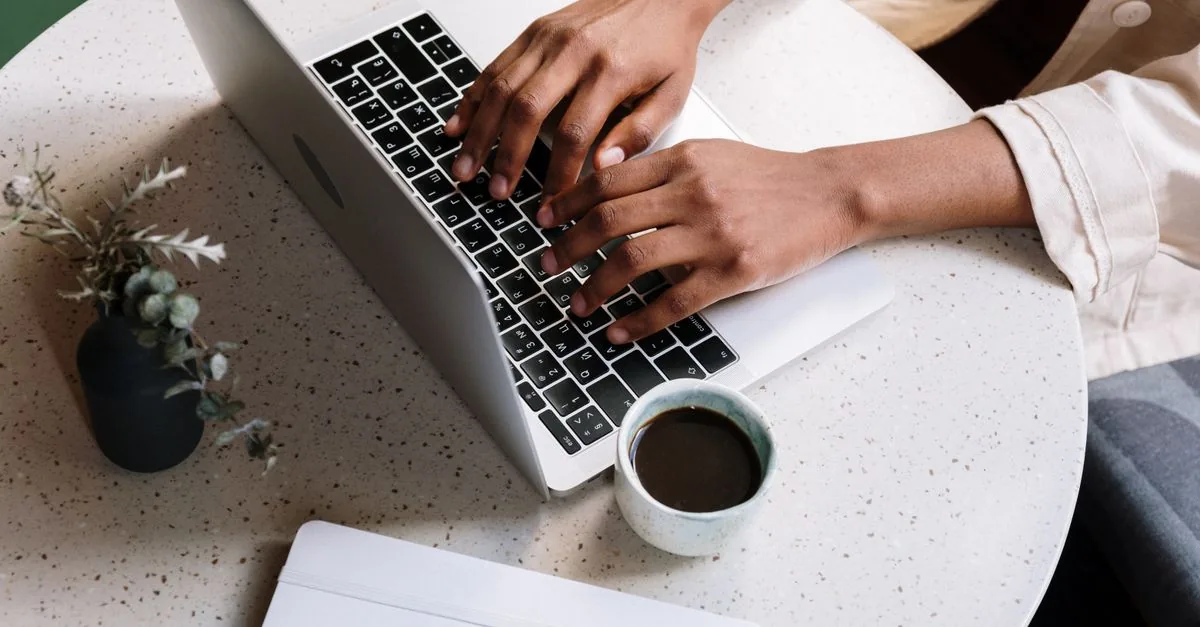 Laptop con un blog abierto junto a una taza de café
