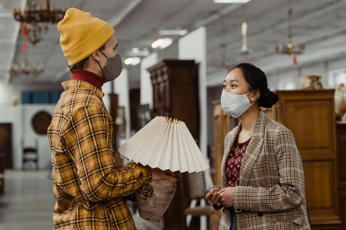 Pareja conversando con un vendedor frente a un refrigerador en una tienda de electrodomésticos