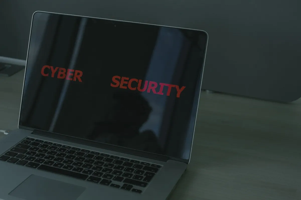 Persona revisando la configuración de seguridad de una cuenta en una laptop junto a una libreta