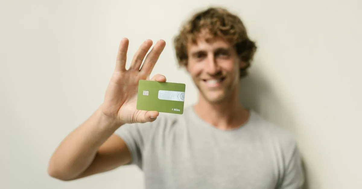 Persona joven sosteniendo su primera tarjeta de crédito