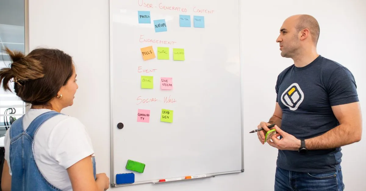 Personas anotando ideas de negocio en un pizarrón blanco