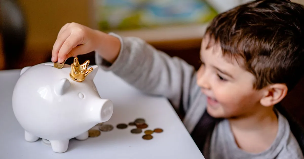 Niño aprendiendo a ahorrar con una alcancía