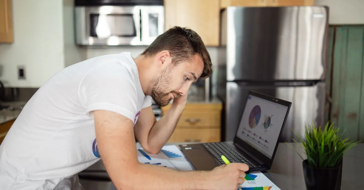 Hombre de cuarenta y tantos revisando sus finanzas en una laptop en casa