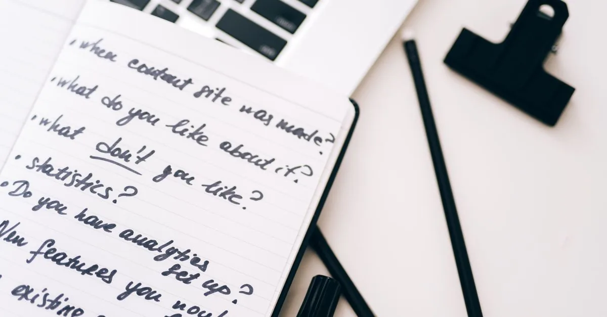 Persona creando contenido en una laptop con una libreta