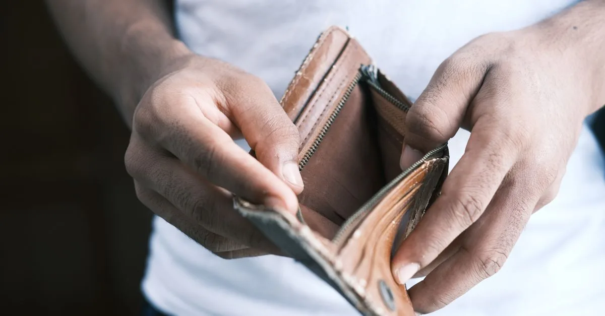 Persona preocupada revisando su cartera vacía