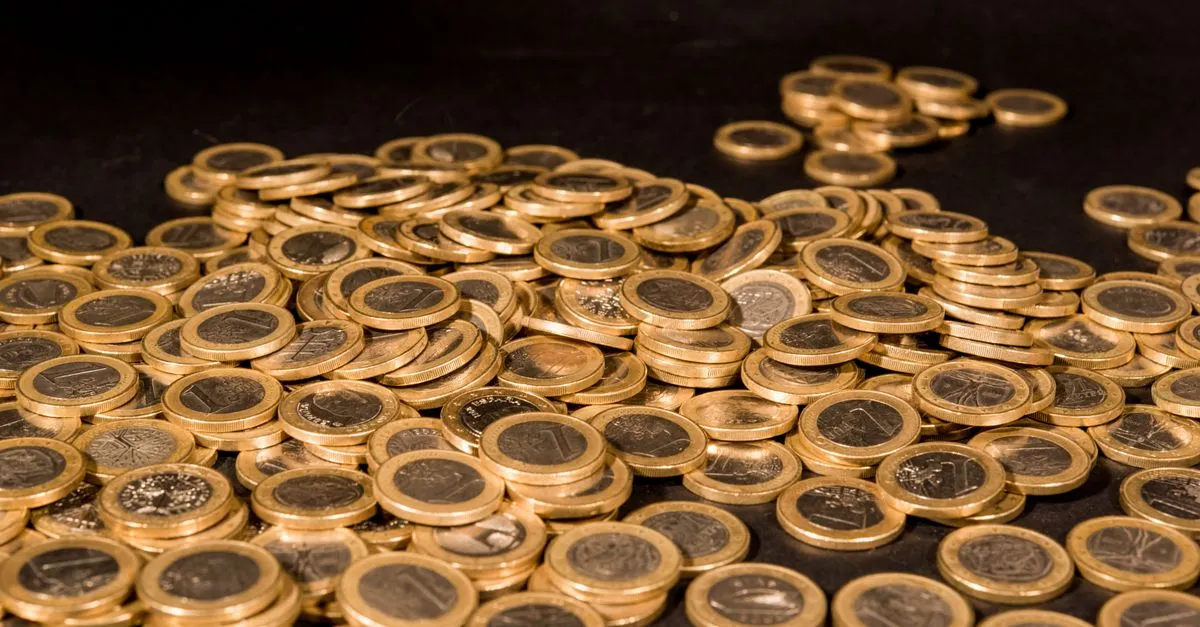 Monedas apiladas en un montón grande y otro pequeño