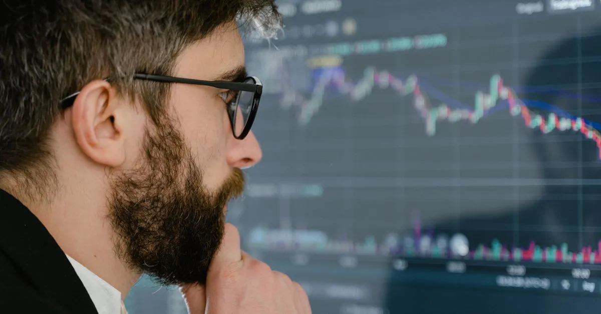 Persona observando con cautela una gráfica financiera en pantalla