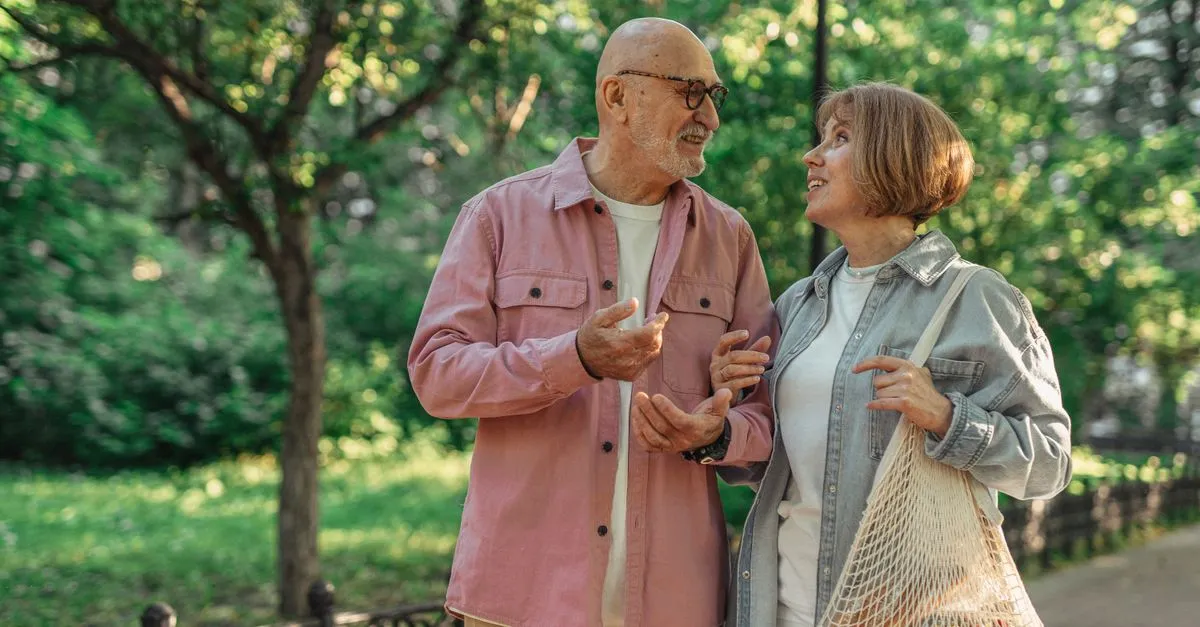 Pareja de adultos mayores caminando tranquilos por un parque