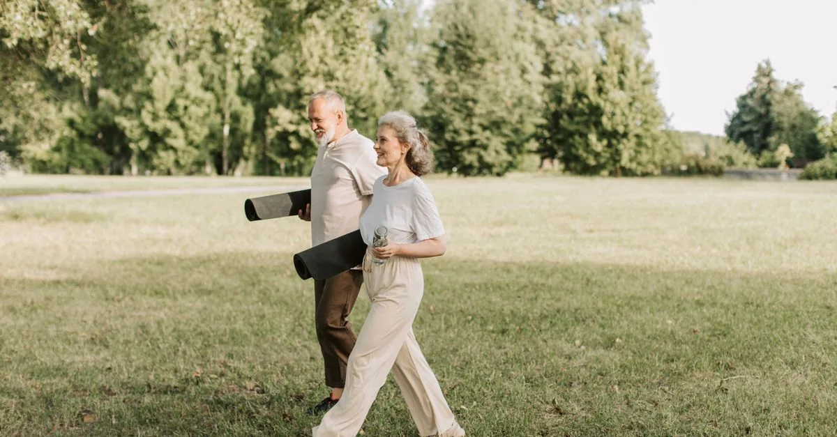 Pareja mayor caminando tranquila por un parque