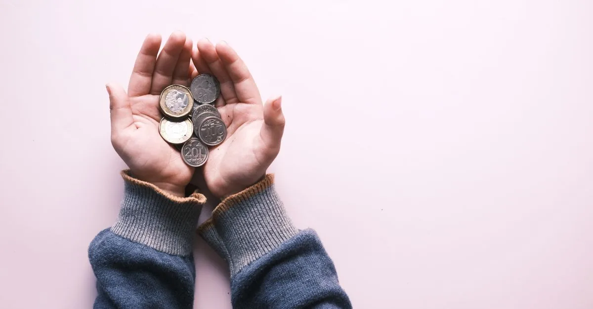 Monedas en la palma de una mano