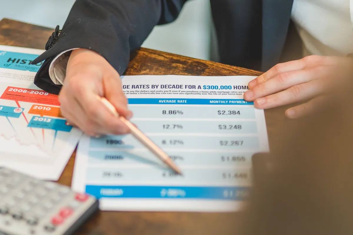 Persona revisando el contrato de un crédito con calculadora sobre la mesa
