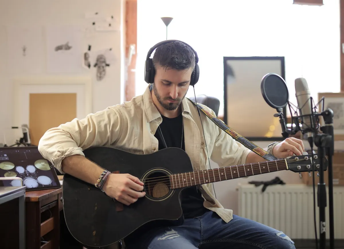 Guitarra acústica junto a un cuaderno con anotaciones sobre una mesa de madera