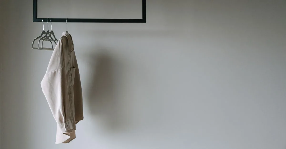 Perchero con ropa básica ordenada por colores en un clóset