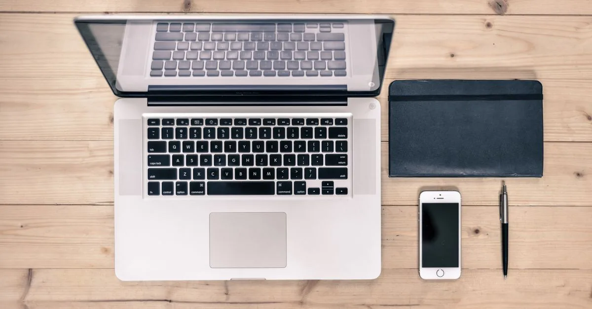 Teléfono inteligente y laptop sobre un escritorio de trabajo