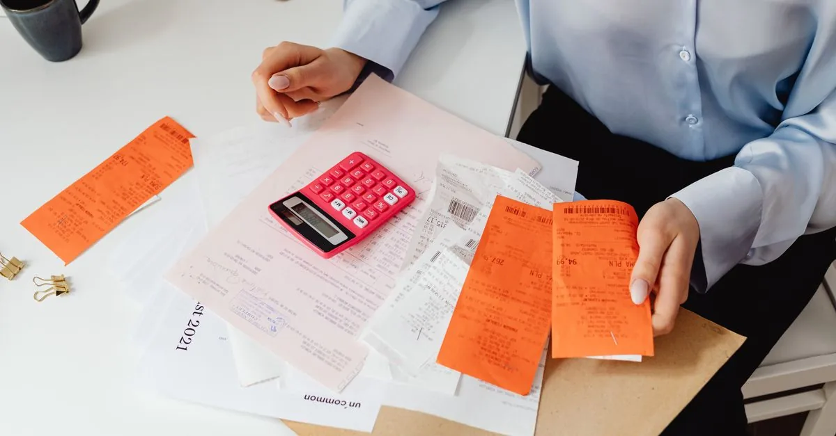 Persona revisando las cuentas del mes con una calculadora
