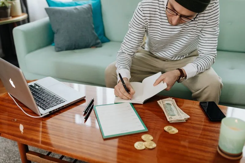 Persona anotando su presupuesto en un cuaderno